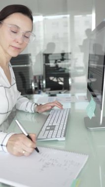 Profesyonel iş kadını bilgisayardaki finansal veri tablolarını analiz ediyor, ofis masasında piyasa araştırması ve iş stratejisi uyguluyor. İş adamları konsepti