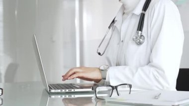Profesyonel kadın doktor online danışmanlık yapıyor ya da sağlık kliniğindeki bilgisayarla hasta kayıtlarını belgeliyor. Tıp, sağlık ve bilim konsepti