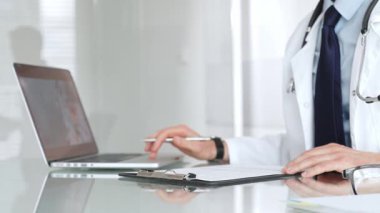 Doktor, açık modern bir klinikte hastaya danışmanlık yaparken panoya notlar yazıyor. Sağlık ve tıp konsepti. Tıp, sağlık ve bilim konsepti