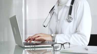 Profesyonel kadın doktor online danışmanlık yapıyor ya da sağlık kliniğindeki bilgisayarla hasta kayıtlarını belgeliyor. Tıp, sağlık ve bilim konsepti