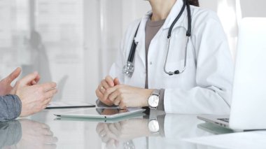 Doktor, klinik muayenesi, profesyonel bakım tartışması sırasında tıbbi verileri incelemek için tablet kullanan hastaya tedavi seçeneklerini açıklıyor. İlaç ve sağlık hizmetleri