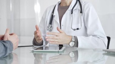 Doktor, klinik muayenesi, profesyonel bakım tartışması sırasında tıbbi verileri incelemek için tablet kullanan hastaya tedavi seçeneklerini açıklıyor. İlaç ve sağlık hizmetleri