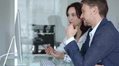 İş arkadaşları bilgisayar ekranında gösterilen finansal grafik ve grafikleri analiz ederek strateji ve piyasa performansını tartışıyor. İş insanları kavramı