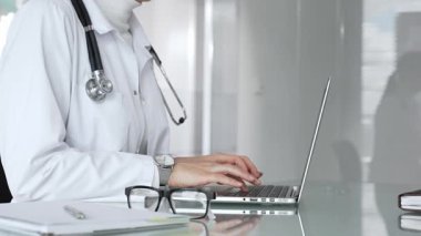 Profesyonel kadın doktor online danışmanlık yapıyor ya da sağlık kliniğindeki bilgisayarla hasta kayıtlarını belgeliyor. Tıp, sağlık ve bilim konsepti
