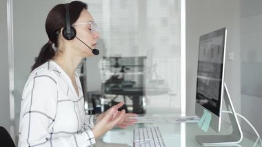 Uzaktan çalışan, mikrofonlu kulaklık takan, müşteri hizmetleri sunan, danışmanlık yapan ya da video konferansına katılan bir kadın. İş adamları konsepti