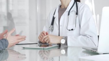 Doktor, klinik muayenesi, profesyonel bakım tartışması sırasında tıbbi verileri incelemek için tablet kullanan hastaya tedavi seçeneklerini açıklıyor. İlaç ve sağlık hizmetleri
