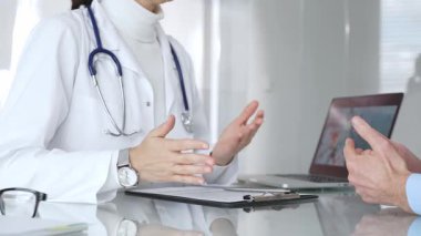 Doktorlar, modern bir klinikte muayene sırasında bir hastayla iletişim kurar, tıbbi seçenekleri açıklar ve profesyonel tavsiyelerde bulunurlar. Tıp, sağlık ve bilim konsepti