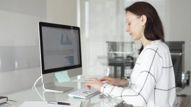 Bir projede işbirliği yapan iş ekibi, bilgisayar ekranında çizelge ve raporları analiz ederek stratejik planlama için veri kavrayışlarını tartışıyor. İş insanları kavramı