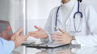 Doktorlar, modern bir klinikte muayene sırasında bir hastayla iletişim kurar, tıbbi seçenekleri açıklar ve profesyonel tavsiyelerde bulunurlar. Tıp, sağlık ve bilim konsepti