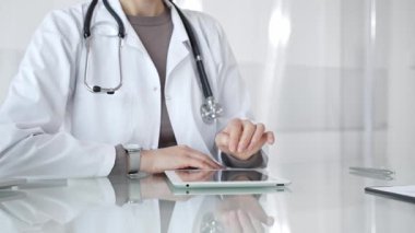 Doktor dijital tablete dokunuyor klinikteki tıbbi kayıtları inceliyor, sağlık uzmanı hastanedeki modern teknolojiyi kullanıyor. İlaç ve sağlık hizmetleri