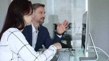 Bir projede işbirliği yapan iş ekibi, bilgisayar ekranında çizelge ve raporları analiz ederek stratejik planlama için veri kavrayışlarını tartışıyor. İş insanları kavramı