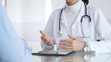 Doktorlar, modern bir klinikte muayene sırasında bir hastayla iletişim kurar, tıbbi seçenekleri açıklar ve profesyonel tavsiyelerde bulunurlar. Tıp, sağlık ve bilim konsepti