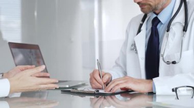 Doktor, açık modern bir klinikte hastaya danışmanlık yaparken panoya notlar yazıyor. Sağlık ve tıp konsepti. Tıp, sağlık ve bilim konsepti