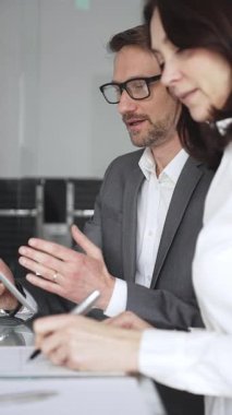 Profesyonel iş adamı ve meslektaşları el çırpıyor, şirket ofisinde yapılan bir iş toplantısında başarı, başarı ve olumlu sonuçlar için takdir ve coşku gösteriyorlar.