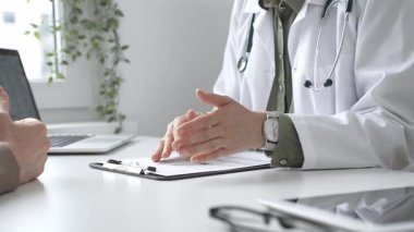 Doktor, tıbbi muayene sırasında hastaya el kol hareketi yaparak teşhisi açıklıyor. İlaç ve sağlık hizmetleri kavramı.