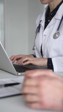 Doctor hands typing on a laptop, documenting treatment plan or giving medical advice to patient during a healthcare consultation. Medicine, healthcare and science concept