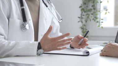 Doktor adam, tıbbi muayenede kadın hastaya teşhis koymayı anlatıyor. Elleriyle işaret ediyor. İlaç ve sağlık hizmetleri kavramı