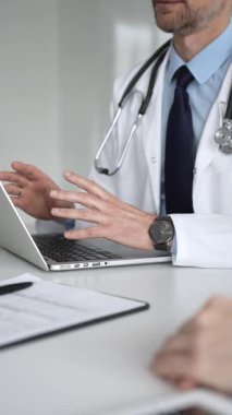 Doktor bir hastaya danışıyor, bilgisayarla tıbbi veri girişi yapıyor. Sağlık ve hasta yönetimine modern bir yaklaşım. Tıp, sağlık ve bilim konsepti