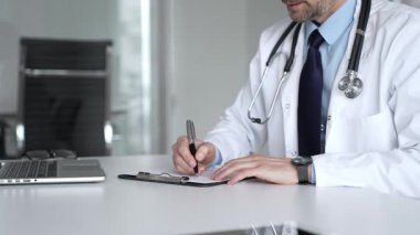 Tıp bürosunda dijital tabletle çalışan, sağlık hizmetleri danışmanlığı sağlayan, tanı ve hasta verileri için teknolojiyi kullanan bir doktor. Tıp, sağlık ve bilim konsepti