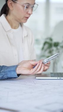 Bir proje üzerinde işbirliği yapan mimarlar, teknik çizimler ve ölçek modelini analiz ederek, mühendislik ve kentsel planlama alanlarında takım çalışması ve profesyonel uzmanlık sergileyerek,