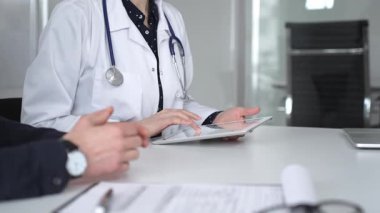 Ofisteki profesyonel sağlık danışmanlığı sırasında hastaların tıbbi geçmişini incelemek için dijital tablet kullanan bir doktor. Tıp, sağlık ve bilim konsepti