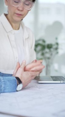 Bir proje üzerinde işbirliği yapan mimarlar, teknik çizimler ve ölçek modelini analiz ederek, mühendislik ve kentsel planlama alanlarında takım çalışması ve profesyonel uzmanlık sergileyerek,