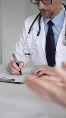 Doktor hastayla iletişim kuruyor, teşhisi açıklıyor ve belgeleri inceliyor. Masadaki sağlık uzmanı tıbbi tavsiye veriyor. Tıp, sağlık ve bilim konsepti