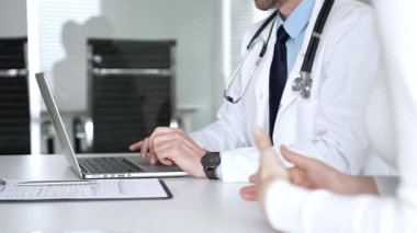 Klinikte tıbbi konsültasyon sırasında hastayla sağlık konusunu tartışan erkek doktor, uzman tavsiyeleri ve tedavi tavsiyeleri sunuyor. Tıp, sağlık ve bilim konsepti