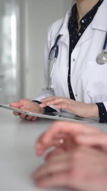 Ofisteki profesyonel sağlık danışmanlığı sırasında hastaların tıbbi geçmişini incelemek için dijital tablet kullanan bir doktor. Tıp, sağlık ve bilim konsepti