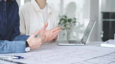 Yenilikçi bir bina projesinde işbirliği yapan mimarlar, modern bir ev modeli tasarlarken aynı zamanda planları analiz eden ve profesyonel bir ofiste mimari tasarım araçları kullanan mimarlar.