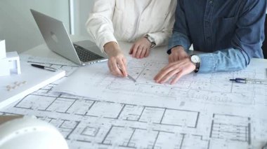 Mimarlar ve mühendisler bir geliştirme projesi üzerinde işbirliği yapıyorlar, fikirleri paylaşıyorlar, bina planlarını gözden geçiriyorlar ve gelecekteki inşaatların tasarım kavramlarını kesinleştirmek için bir yerleşim modelini tartışıyorlar.