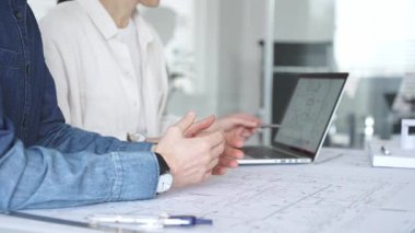 Yenilikçi bir bina projesinde işbirliği yapan mimarlar, modern bir ev modeli tasarlarken aynı zamanda planları analiz eden ve profesyonel bir ofiste mimari tasarım araçları kullanan mimarlar.