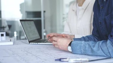 Yenilikçi bir bina projesinde işbirliği yapan mimarlar, modern bir ev modeli tasarlarken aynı zamanda planları analiz eden ve profesyonel bir ofiste mimari tasarım araçları kullanan mimarlar.