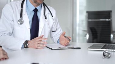 Beyaz önlüklü ve steteskop hastası olan bir doktor profesyonel ofis ortamında sağlık bilgileri ve tedavi seçeneklerini açıklıyor. Tıp, sağlık ve bilim konsepti