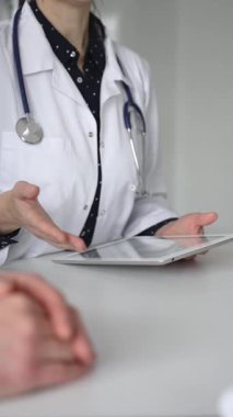 Ofisteki profesyonel sağlık danışmanlığı sırasında hastaların tıbbi geçmişini incelemek için dijital tablet kullanan bir doktor. Tıp, sağlık ve bilim konsepti