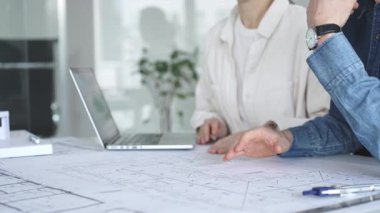 Yenilikçi bir bina projesinde işbirliği yapan mimarlar, modern bir ev modeli tasarlarken aynı zamanda planları analiz eden ve profesyonel bir ofiste mimari tasarım araçları kullanan mimarlar.