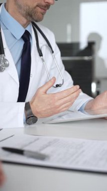 Doktor hastayla iletişim kuruyor, teşhisi açıklıyor ve belgeleri inceliyor. Masadaki sağlık uzmanı tıbbi tavsiye veriyor. Tıp, sağlık ve bilim konsepti
