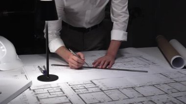 Ayrıntılı bina planları üzerinde çalışan, cetvelle planlar üzerinde ölçüm yapan, yeni yapıları kavramsallaştıran kadın mimar. İş ve mimarlık kavramı