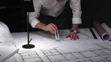 Ayrıntılı bina planları üzerinde çalışan, cetvelle planlar üzerinde ölçüm yapan, yeni yapıları kavramsallaştıran kadın mimar. İş ve mimarlık kavramı