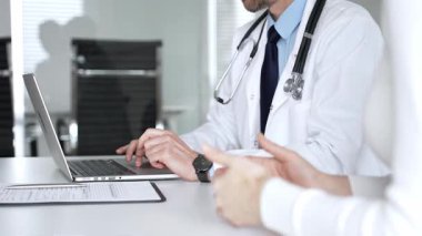 Klinikte tıbbi konsültasyon sırasında hastayla sağlık konusunu tartışan erkek doktor, uzman tavsiyeleri ve tedavi tavsiyeleri sunuyor. Tıp, sağlık ve bilim konsepti