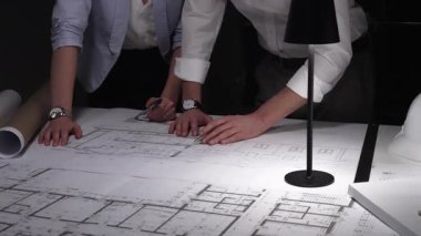 Profesyonel mimarlar ve mühendisler mimari planlar üzerinde birlikte çalışıyor, ofiste yeni inşaat projeleri tasarlıyor ve geliştiriyorlar..