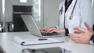 Doktorlar dizüstü bilgisayarda yazarlar, tedavi planlarını belgelerler ya da sağlık danışmanlığı sırasında hastalara tıbbi tavsiyelerde bulunurlar. Tıp, sağlık ve bilim konsepti