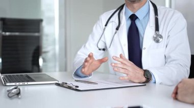 Beyaz önlüklü ve steteskop hastası olan bir doktor profesyonel ofis ortamında sağlık bilgileri ve tedavi seçeneklerini açıklıyor. Tıp, sağlık ve bilim konsepti