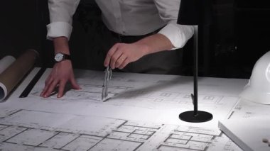 Ayrıntılı bina planları üzerinde çalışan, cetvelle planlar üzerinde ölçüm yapan, yeni yapıları kavramsallaştıran kadın mimar. İş ve mimarlık kavramı