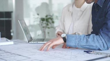 Yenilikçi bir bina projesinde işbirliği yapan mimarlar, modern bir ev modeli tasarlarken aynı zamanda planları analiz eden ve profesyonel bir ofiste mimari tasarım araçları kullanan mimarlar.