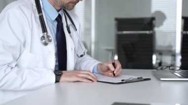 Tıp bürosunda dijital tabletle çalışan, sağlık hizmetleri danışmanlığı sağlayan, tanı ve hasta verileri için teknolojiyi kullanan bir doktor. Tıp, sağlık ve bilim konsepti