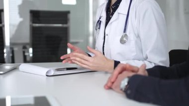 Beyaz önlüklü doktor, bir hastayla tıbbi istişare sırasında panoya notlar yazarak sağlık ve tedaviyi tartışıyor. Tıp, sağlık ve bilim konsepti