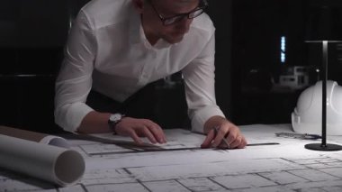 Profesyonel mimar gece geç saatlerde şehir planlarını hazırlıyor, tasarım, planlama ve inşaat detaylarına odaklanıyor. İş ve mimarlık kavramı