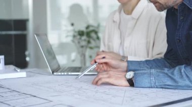 Yenilikçi bir bina projesinde işbirliği yapan mimarlar, modern bir ev modeli tasarlarken aynı zamanda planları analiz eden ve profesyonel bir ofiste mimari tasarım araçları kullanan mimarlar.