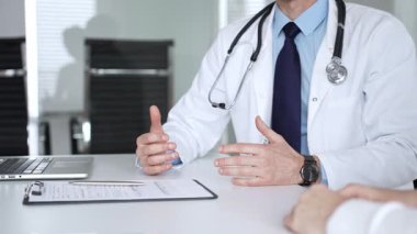 Beyaz önlüklü ve steteskop hastası olan bir doktor profesyonel ofis ortamında sağlık bilgileri ve tedavi seçeneklerini açıklıyor. Tıp, sağlık ve bilim konsepti